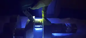 Ensayo por partículas magnetizables fluorescentes con yugo magnético y luz UV en inspección industrial